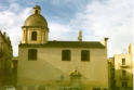 Sul largo del Carmine è visibile l’intera facciata laterale, corrispondente alla parete di sinistra della navata unica della chiesa, dove un portale, ora murato, ripete lo schema decorativo di quello di ingresso (foto Tota) 