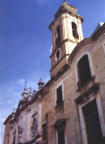 Il campanile, a destra della facciata, visibile oltre la facciata dell'ex convento delle Benedettine, è composto dai due piani e dalla guglia superiore (foto Biccari)